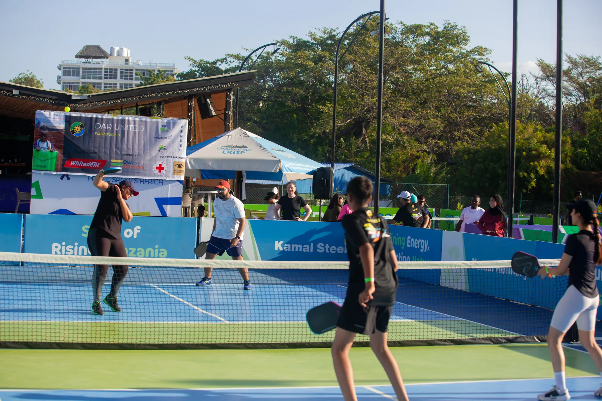 Players at the net with the Dar United sponsor banner behind them